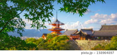 Kyoto, Japan - Oct 11 2024, panoramic view through foliage of Kiyomizu-Dera temple complex with a pagoda, with a clear blue sky and a forest in foreground, at daytime, blurred, Kyoto, Japan Kyoto, Japan - Oct 11 2024, panoramic view through foliage of Kiyomizu-Dera temple complex with a pagoda, with a clear blue sky and a forest in foreground, at daytime, blurred, Kyoto, Japan 138964897