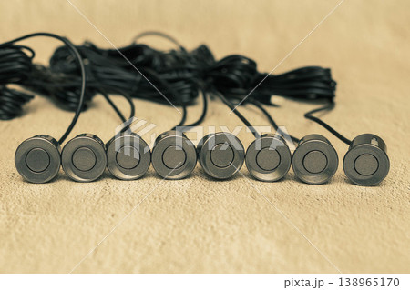 Grey parking sensors with wires on the concrete surface Grey parking sensors with wires on the concrete surface 138965170