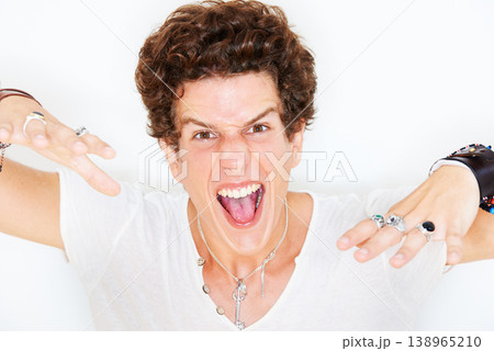 Portrait, energy and crazy with a man in studio isolated on a white background for the expression of emotion. Face, fashion and freedom with an edgy young model looking wild or fierce rockstar style Portrait, energy and crazy with a man in studio isolated on a white background for the expression of emotion. Face, fashion and freedom with an edgy young model looking wild or fierce rockstar style 138965210