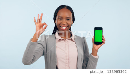Business woman, ok sign and green screen phone with portrait for review, choice or app by blue background. African entrepreneur, yes and studio for smartphone mockup, chromakey or tracking markers Business woman, ok sign and green screen phone with portrait for review, choice or app by blue background. African entrepreneur, yes and studio for smartphone mockup, chromakey or tracking markers 138965362