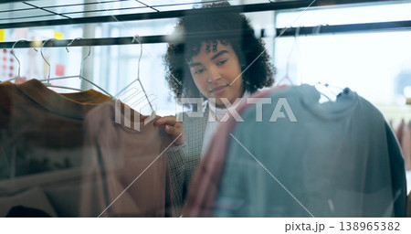 Shopping, fashion and woman thinking in a mall for clothes, search or outfit choice. Retail, deal and female customer check fabric, texture or quality in a thrift store for discount, sale or decision 138965382