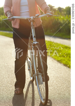 Nature, fitness and woman on a bicycle for exercise, workout and training on a street in park. Sports, health and closeup of female person cycling on a bike for an outdoor adventure in a garden. 138965486