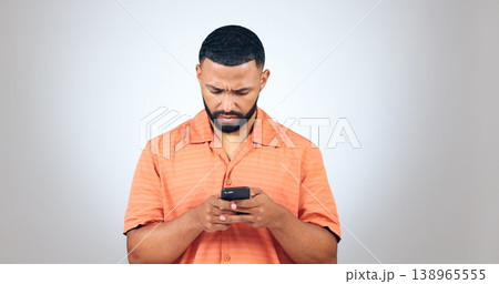 Confused, text and man in studio reading fake news, email or error notification on grey background. Doubt, smartphone and male model with with app password glitch, 404 or phishing, scam or review Confused, text and man in studio reading fake news, email or error notification on grey background. Doubt, smartphone and male model with with app password glitch, 404 or phishing, scam or review 138965555