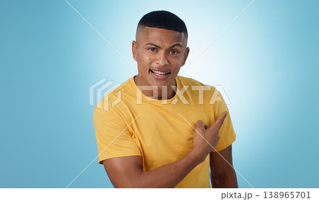 Pointing, question and portrait of man in a studio with mockup for marketing, advertising or promotion. Confused, thinking and young male person with a show hand gesture isolated by blue background. 138965701