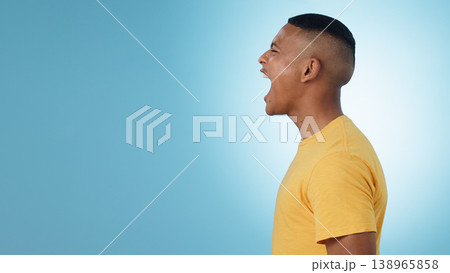 Angry, man and scream in studio at mockup space for crisis, anger or mad emoji reaction on blue background. Profile of frustrated model shouting with stress, emotional conflict or negative expression 138965858