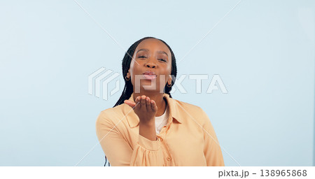 Love, black woman and blowing a kiss in portrait, studio and blue background with flirting or romance. Lips, pouting and gen z person or emoji with confidence, happiness and mock up space with care Love, black woman and blowing a kiss in portrait, studio and blue background with flirting or romance. Lips, pouting and gen z person or emoji with confidence, happiness and mock up space with care 138965868
