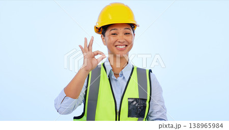Woman, okay and hands in smile by engineer for construction by architect in studio by blue background. Asian female, development or success for real estate, inspection and yes sign or emoji in mockup Woman, okay and hands in smile by engineer for construction by architect in studio by blue background. Asian female, development or success for real estate, inspection and yes sign or emoji in mockup 138965984