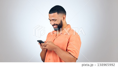 Phone, chat and happy man laugh in studio with online comic, meme or funny text on grey background. Smartphone, smile or male model with app joke, humor and contact or web, network or communication 138965992