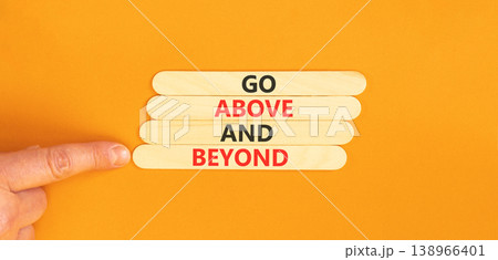 Go above and beyond symbol. Concept words Go above and beyond on beautiful wooden sticks. Beautiful orange background. Businessman hand. Business motivational Go above and beyond concept. Copy space. Go above and beyond symbol. Concept words Go above and beyond on beautiful wooden sticks. Beautiful orange background. Businessman hand. Business motivational Go above and beyond concept. Copy space. 138966401