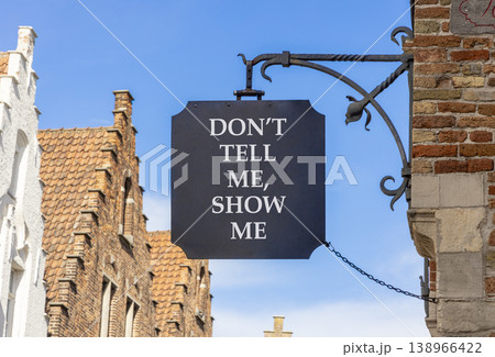 Tell or show symbol. Concept words Do not tell me, show me on beautiful black road sign. Beautiful blue sky and buildings background. Business tell or show concept. Copy space. 138966422