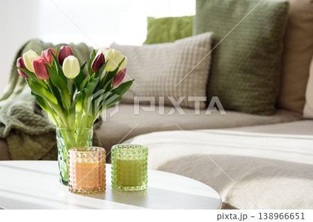 Living Room Decorated Spring Tulip Bouquet in Green Vase and Candles. Cozy Home Decor Arrangement Living Room Decorated Spring Tulip Bouquet in Green Vase and Candles. Cozy Home Decor Arrangement 138966651