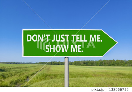 Tell or show symbol. Concept words Do not just tell me, show me beautiful green road sign. Beautiful blue sky green field background. Business tell or show concept. Copy space. 138966733