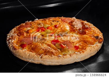 Burnt homemade pizza on tray in electric oven Burnt homemade pizza on tray in electric oven 138966824
