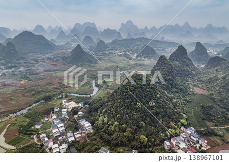 Misty hills rise gently behind a quiet village of China Misty hills rise gently behind a quiet village of China 138967101