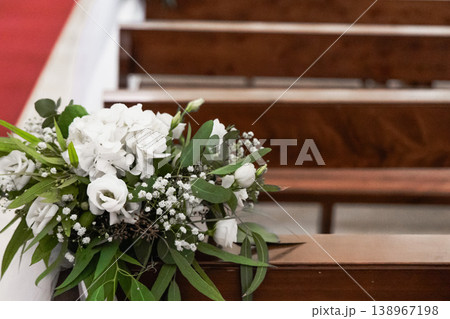 White flowers decorating pews in church interior 138967198