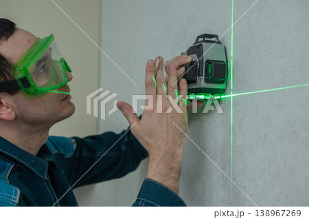 A man measures distance with a laser level. A man measures distance with a laser level. 138967269