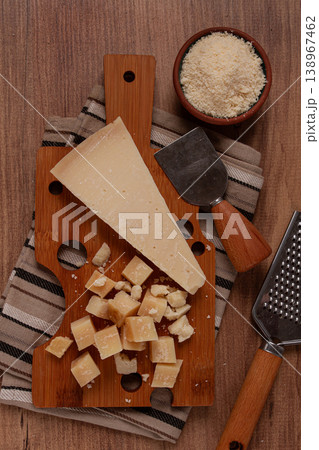 Freshly sliced and grated cheese, parmesan cheese, on a wooden chopping board, rustic style, no people Freshly sliced and grated cheese, parmesan cheese, on a wooden chopping board, rustic style, no people 138967462
