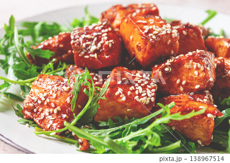 fried salmon slices, teriyaki with sesame seeds, with arugula salad, top view, 138967514