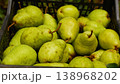 The farmer's hands put ripe pears just picked from the tree into a box. 138968202