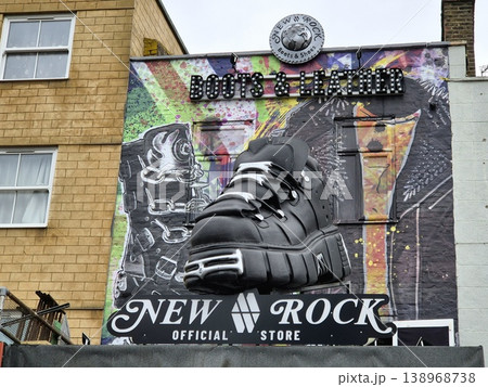 London UK 05.07.2025 New Rock boots and leather store facade with large shoe sculpture and colorful graffiti background showcasing bold fashion style and alternative culture in Camden street London UK 05.07.2025 New Rock boots and leather store facade with large shoe sculpture and colorful graffiti background showcasing bold fashion style and alternative culture in Camden street 138968738