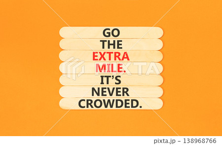 Go the extra mile symbol. Concept words Go the extra mile. It's never crowded on beautiful wooden sticks. Beautiful orange paper background. Business go the extra mile concept. Copy space. Go the extra mile symbol. Concept words Go the extra mile. It's never crowded on beautiful wooden sticks. Beautiful orange paper background. Business go the extra mile concept. Copy space. 138968766
