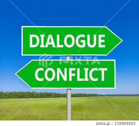 Dialogue instead conflict symbol. Concept words Dialogue and Conflict on beautiful green road sign. Beautiful blue sky green grass background. Social and dialogue instead conflict concept. Copy space. 138968803