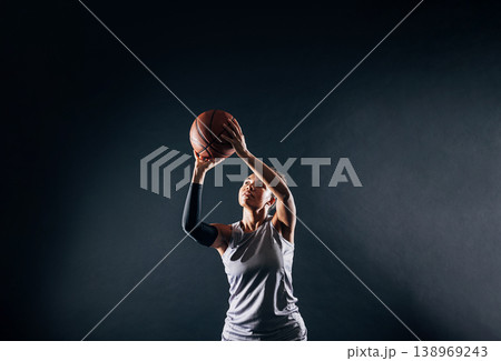 Pro basketball female player posing with a ball in studio Pro basketball female player posing with a ball in studio 138969243