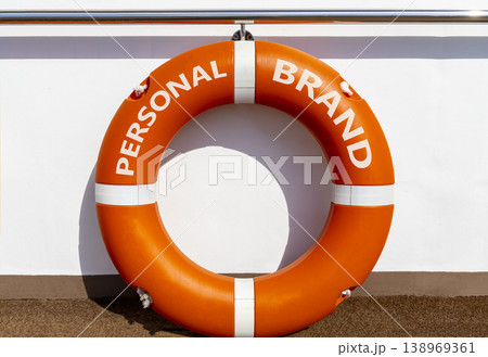 Personal brand symbol. Concept words Personal brand on beautiful orange lifebuoy. Beautiful white ship's board background. Business personal brand concept. Copy space. Personal brand symbol. Concept words Personal brand on beautiful orange lifebuoy. Beautiful white ship's board background. Business personal brand concept. Copy space. 138969361