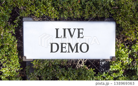 Live demo symbol. Concept words Live demo on beautiful big white sign plate. Beautiful green garden background. Copy space. Business and live demo concept. Live demo symbol. Concept words Live demo on beautiful big white sign plate. Beautiful green garden background. Copy space. Business and live demo concept. 138969363