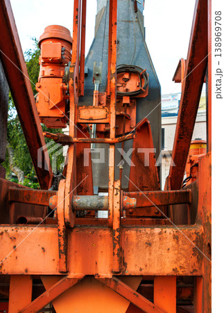 Close up of rusty crane machinery showing metal joints, cables, and hydraulic components in an industrial construction setting. Close up of rusty crane machinery showing metal joints, cables, and hydraulic components in an industrial construction setting. 138969708