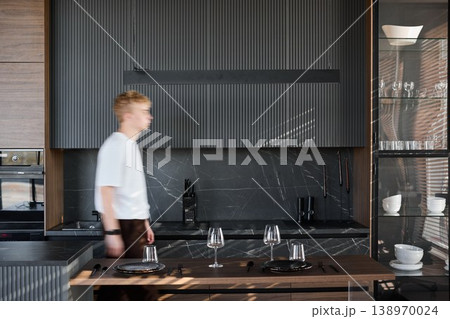 Male individual cooking with utensils in home kitchen setting 138970024