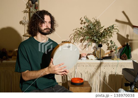 Creative craftsman displays handpan and frame drum in studio setting Creative craftsman displays handpan and frame drum in studio setting 138970038