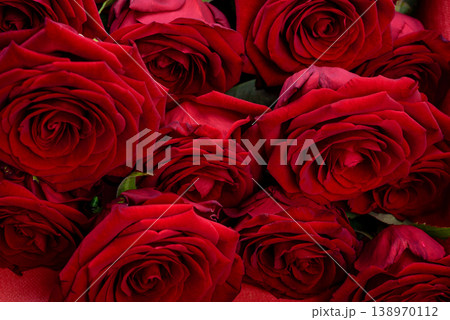 A luxurious bouquet of dark red roses close-up with a velvety texture. A luxurious bouquet of dark red roses close-up with a velvety texture. 138970112