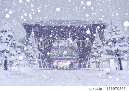 雪が舞う金沢駅鼓門 138970865