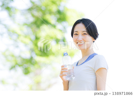 新緑の屋外で水分補給をする女性の横顔ポートレート　ウォーキングやランニングの運動 138971866