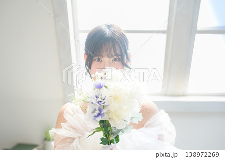 ブーケで顔を隠すウェディングドレス姿の日本人女性 ブーケで顔を隠すウェディングドレス姿の日本人女性 138972269
