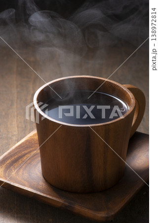 木製のコーヒカップに湯気の立ち上るホットコーヒー 138972814