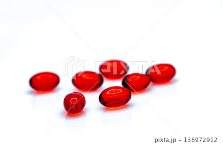 Red soft gel capsule pills isolated on white background. Pile of red soft gelatin capsule. Vitamins and dietary supplements concept. Pharmaceutical industry. Pharmacy drug store. Health care products. 138972912