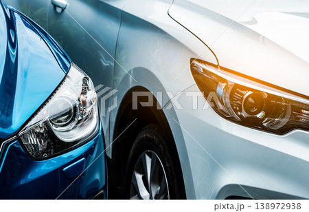 Close up headlamp light of blue and white SUV car. Blue car parked beside white car. Automotive industry concept. Electric or hybrid auto concept. Car service. Road trip adventure. Automobile rental. Close up headlamp light of blue and white SUV car. Blue car parked beside white car. Automotive industry concept. Electric or hybrid auto concept. Car service. Road trip adventure. Automobile rental. 138972938