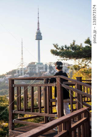 Korean young man view N Seoul tower with cherry blossom at sunset 138973574