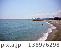 Sunny coastal beach with gentle waves and curving shoreline in summer 138976298