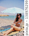 Woman relaxing on beach under umbrella during summer vacation 138976299