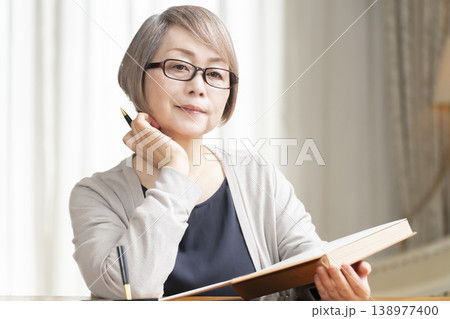リビングでエンディングノートを書くシニア女性 138977400
