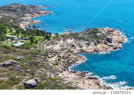 Aerial view of Rose Bay in Bowen, Queensland, Australia. The scene shows a tropical coastal landscape with clear blue water, sandy shoreline and surrounding natural environment. Aerial view of Rose Bay in Bowen, Queensland, Australia. The scene shows a tropical coastal landscape with clear blue water, sandy shoreline and surrounding natural environment. 138978353