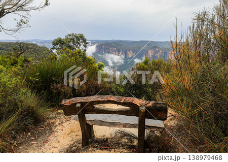 Scenic view of a timber bench seat overlooking Perrys Lookdown in the Blue Mountains, New South Wales, Australia. The lookout offers expansive views across deep forested valley 138979468