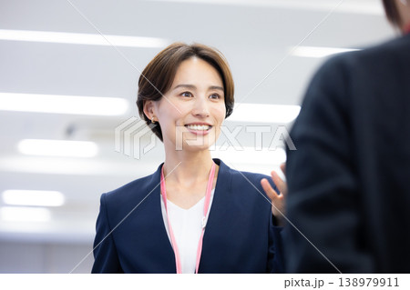 ビジネス　同僚と話ししている女性 138979911