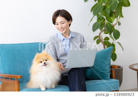 ライフスタイル パソコンを見ている飼い主さんの隣でくつろぐ犬 ライフスタイル パソコンを見ている飼い主さんの隣でくつろぐ犬 138980925