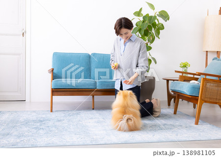ライフスタイル リビングでくつろぐ女性と愛犬 ライフスタイル リビングでくつろぐ女性と愛犬 138981105