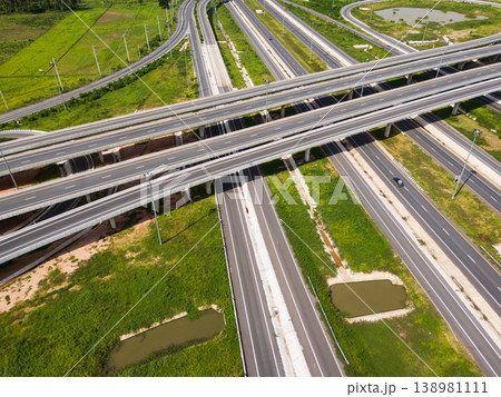 Drone shot a large highway interchange crossing over green farmlands in Thailand Drone shot a large highway interchange crossing over green farmlands in Thailand 138981111