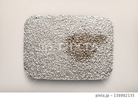 Clumping cat litter filler, taken without a drawer, as if in glass, top view, pet hygiene concept with absorbent used catTop view of clumping cat litter in a litter box with a visible used clump. The 138982135